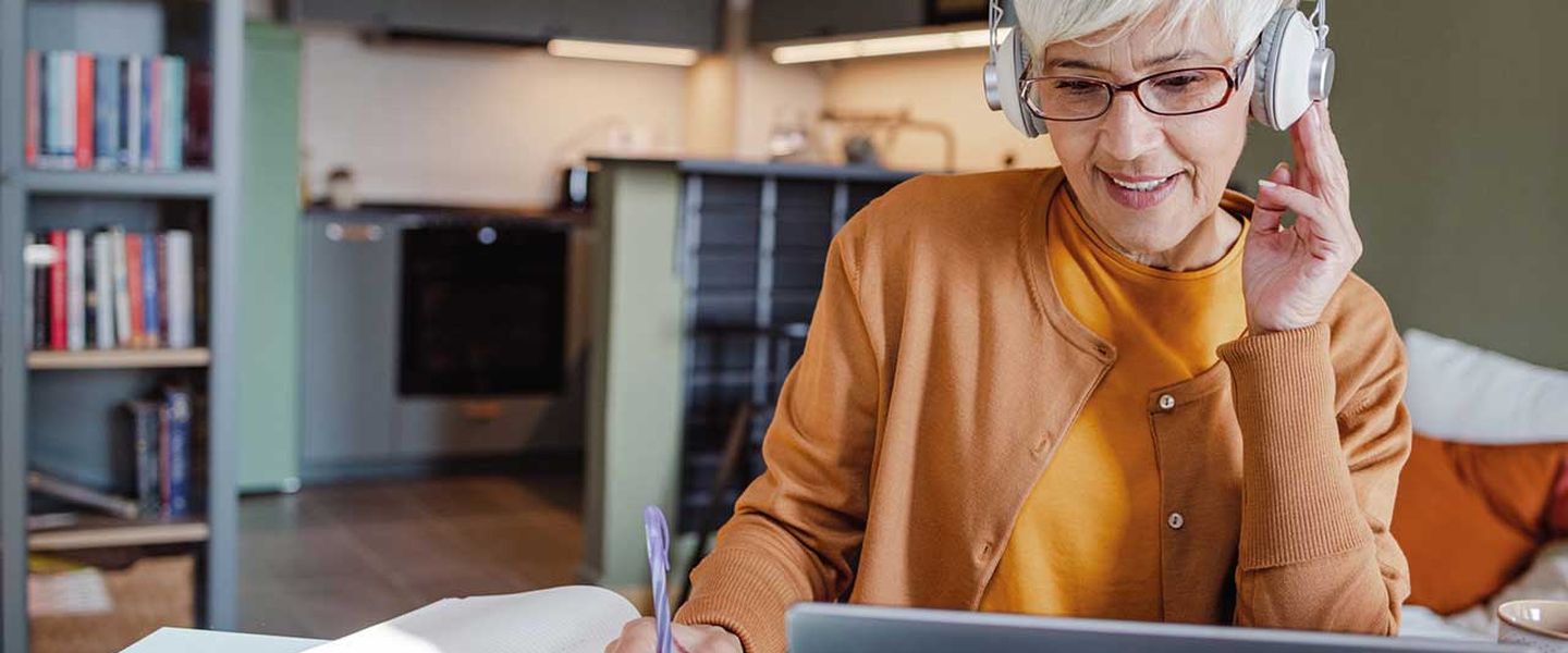 Frau nimmt zu Hause an einem Web-Seminar für Photovoltaik teil. © blackCAT / E+ via Getty Images. © blackCAT / E+ via Getty Images.