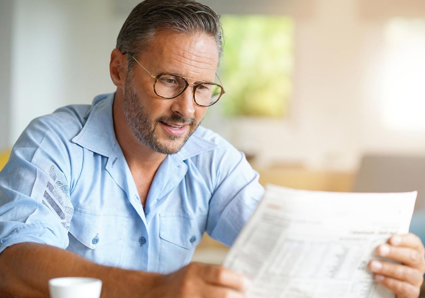 Man mit Brille liest ein Dokument