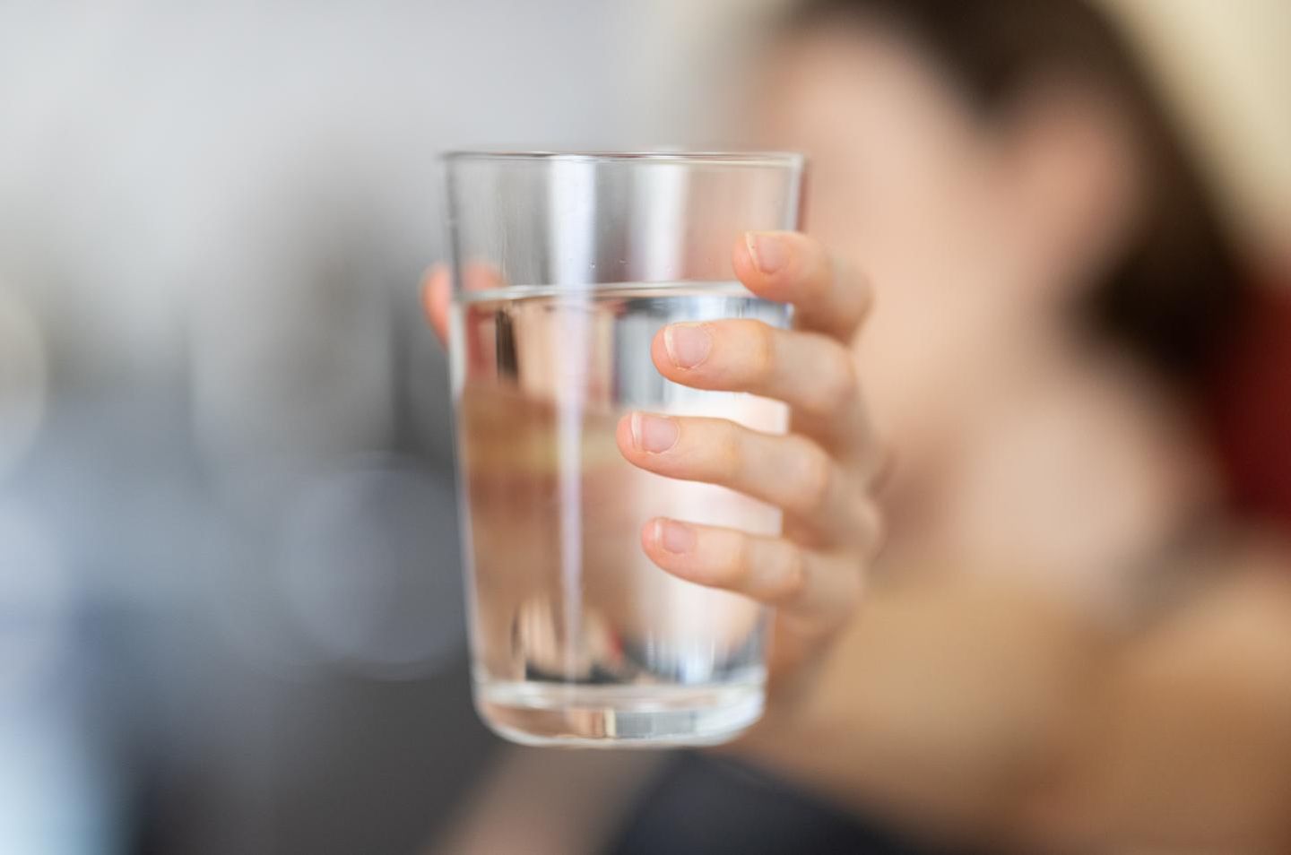 Eine Frau hält ein Wasserglas in der Hand