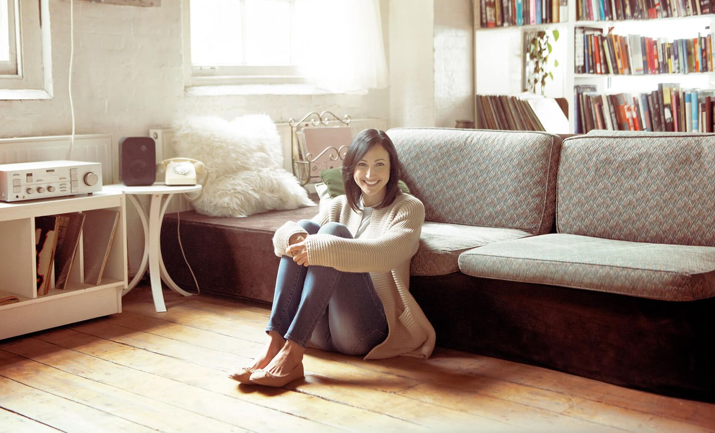 Eine Frau sitzt auf dem Boden vor der Couch