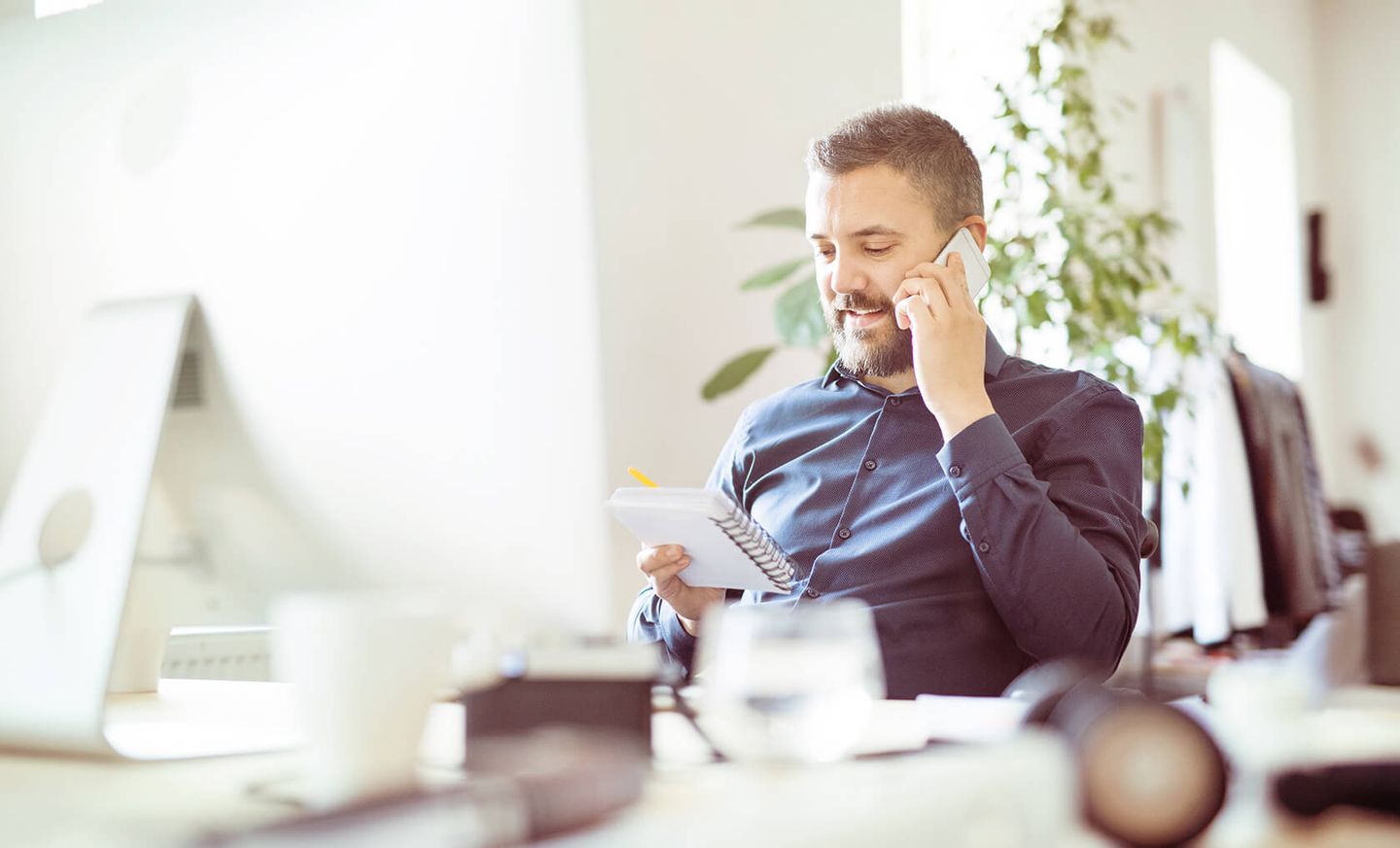 Geschäftkunden: ein Mann sitzt am PC und telefoniert