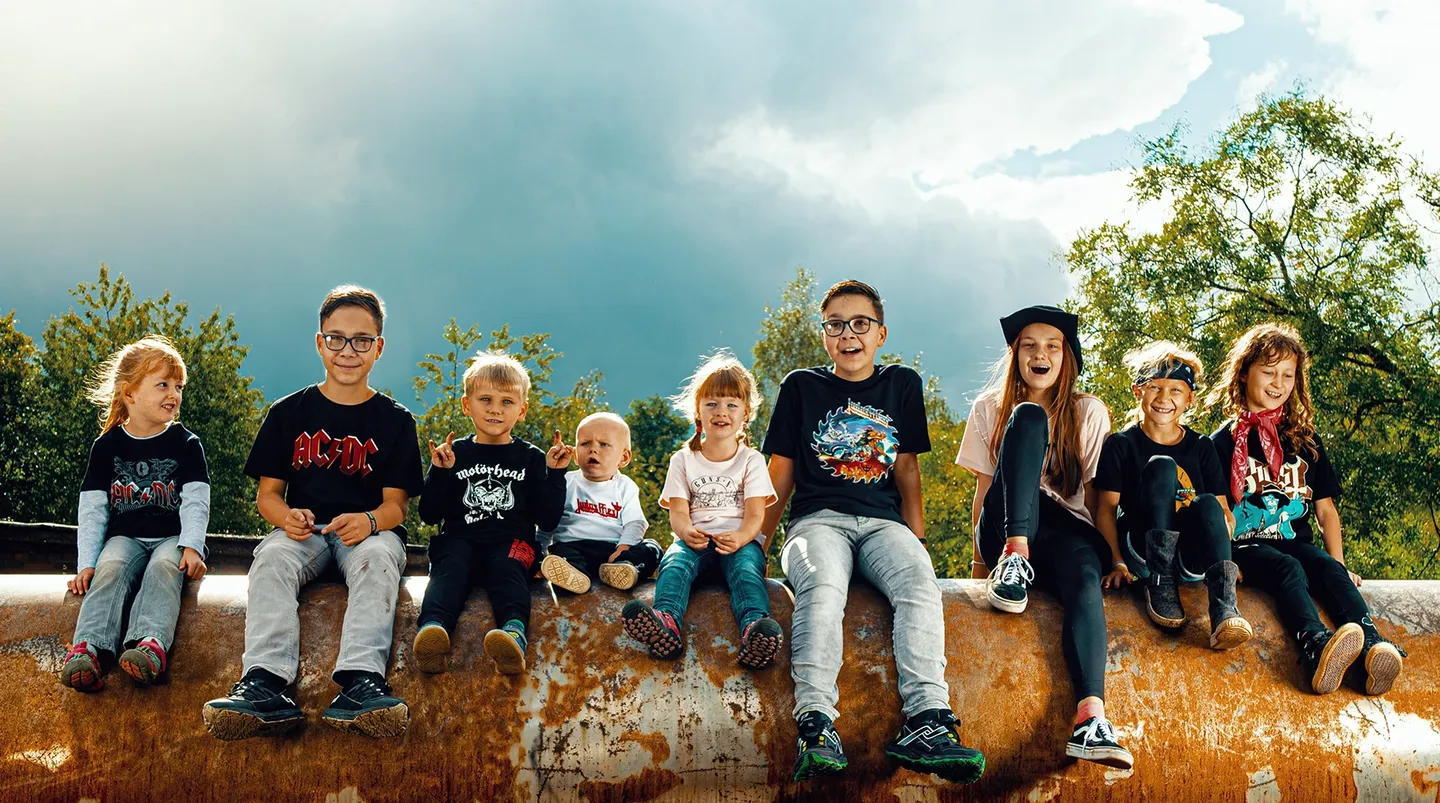 Kinder in einer Reihe, die Kleidung aus dem Metal Kids Shop tragen