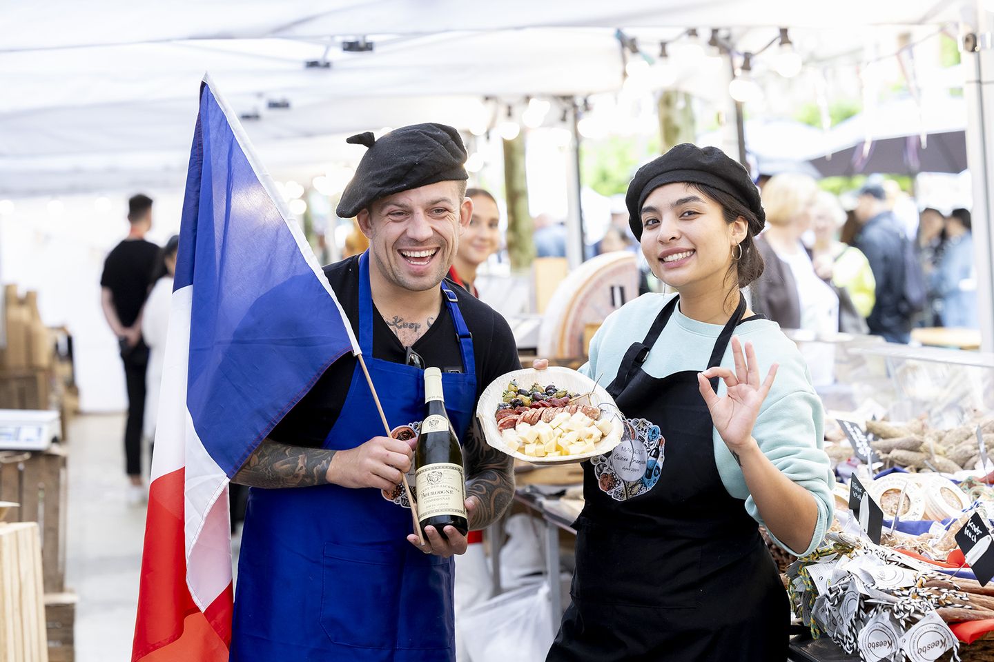 Mann und Frau mit Baskenmütze präsentieren französischen Käse, Wein und eine Frankreichflagge. © Destination Düsseldorf Veranstaltungs GmbH / Wellfairs GmbH via www.duesseldorfer-frankreich-fest.de © Destination Düsseldorf Veranstaltungs GmbH / Wellfairs GmbH via www.duesseldorfer-frankreich-fest.de