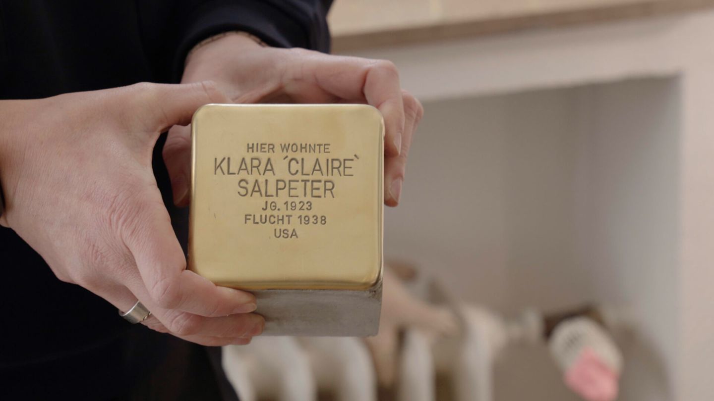 Ein Stolperstein mit der Aufschrift „Hier wohnte Klara ‚Claire‘ Salpeter Jg. 1923 Flucht 1938 USA“ wird von einer Person in den Händen gehalten. © Stadtwerke Düsseldorf