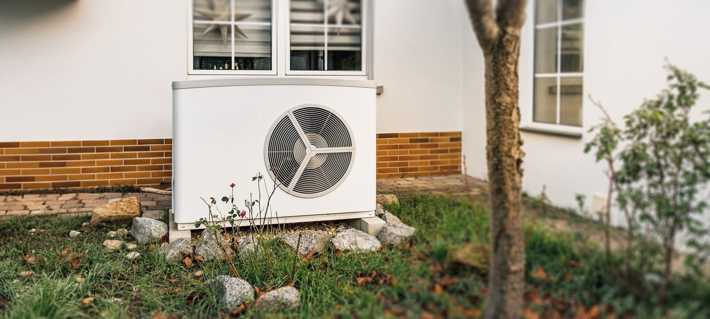 Eine Wärmepumpe vor einem Wohnhaus