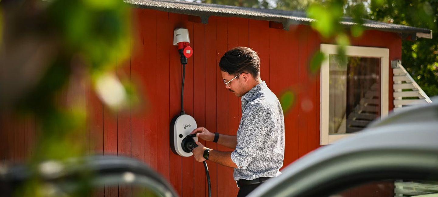 Mann schließt ein Ladegerät für Elektroautos an © Go-e