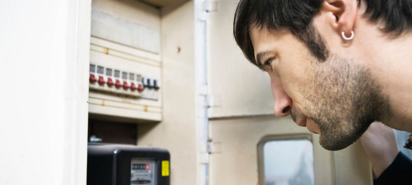 Ein junger Mann liest den Zählerstand in einem Sicherungskasten ab. © Bernd Vogel / Stone via Getty Images © Bernd Vogel / Stone via Getty Images
