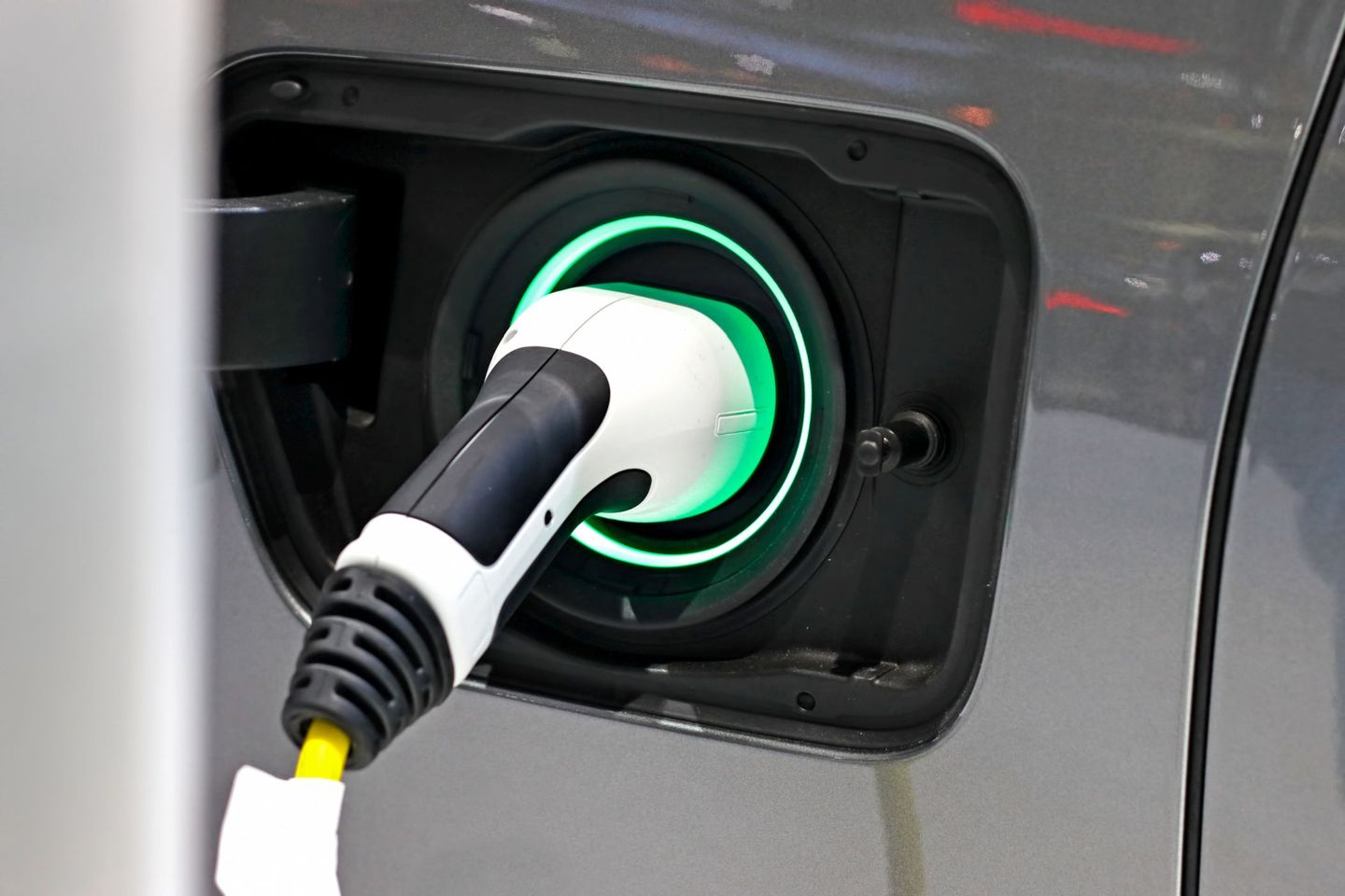 Wallbox anmelden: Nahaufnahme von einem Netzteil, das an ein E-Auto angesteckt wurde, um es aufzuladen. © Rapeepong Puttakumwong / Moment via Getty Images