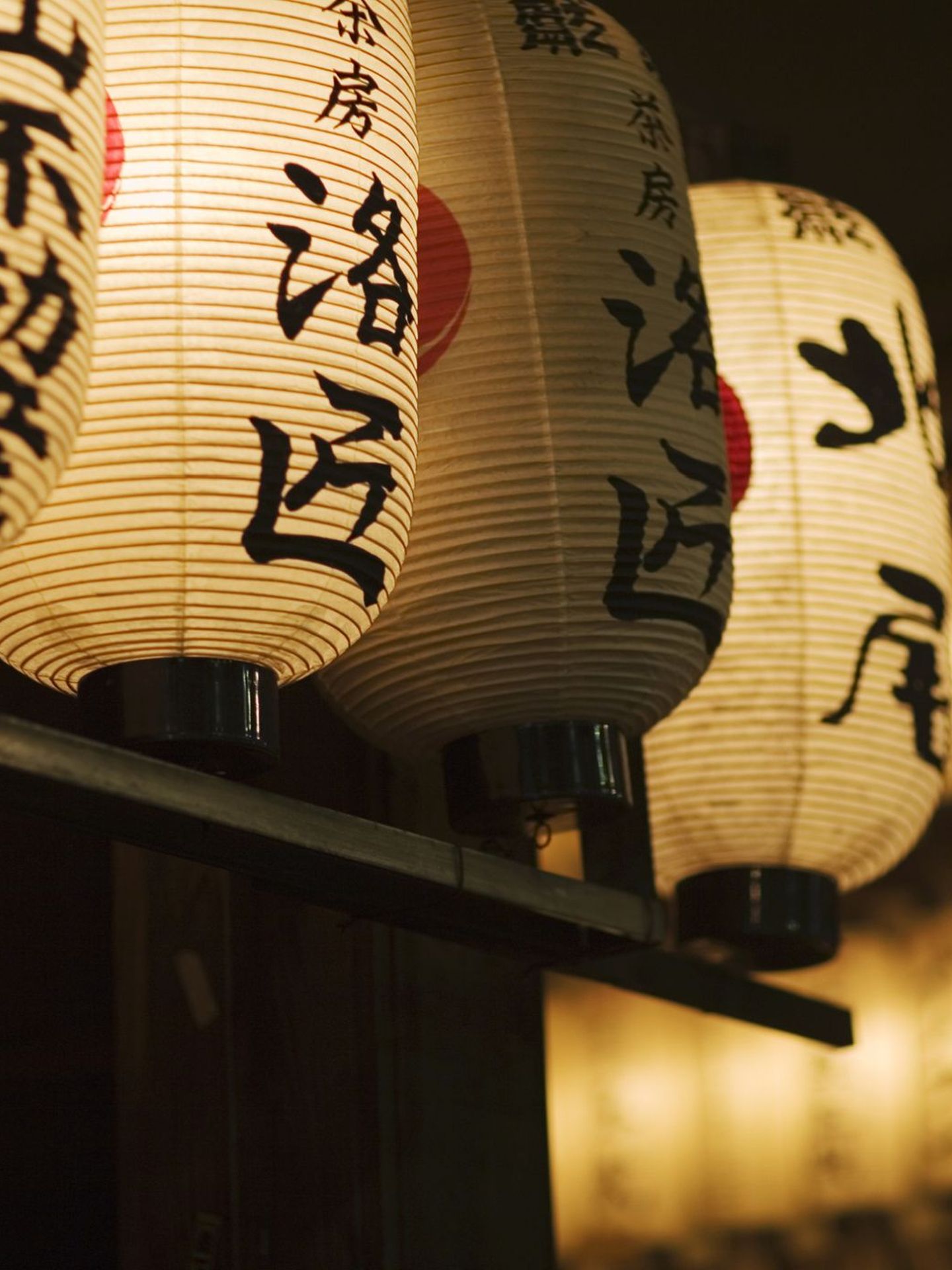 Japanische Papierlampen hängen im Dunkeln © Matt Henry Gunther / The Image Bank via Getty Images © Matt Henry Gunther / The Image Bank via Getty Images