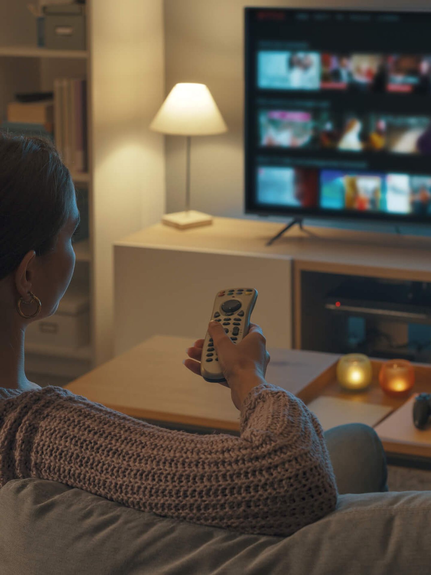 Frau sitzt auf dem Sofa und schaut Fernsehen.© demaerre / iStock / Getty Images Plus
