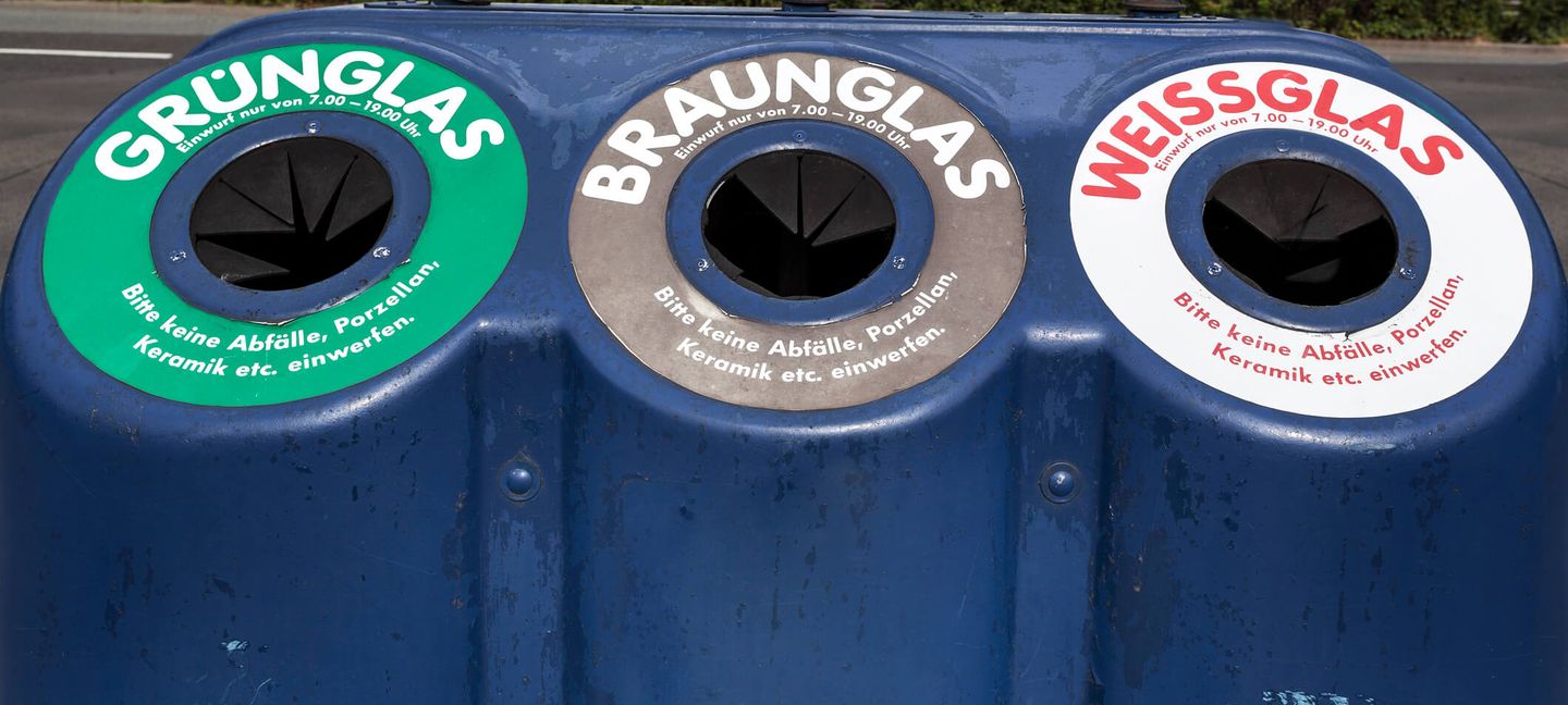 Ein Glascontainer mit Einwürfen für Grün-, Braun- und Weißglas.
