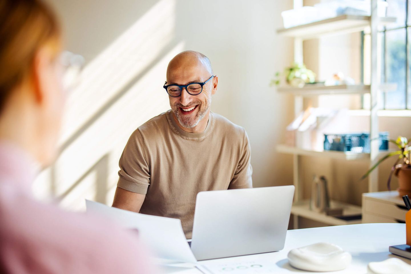 Ein Mann sitzt lächelnd an seinem Schreibtisch. © FreshSplash / iStock / Getty Images Plus via Getty Images © FreshSplash / iStock / Getty Images Plus via Getty Images