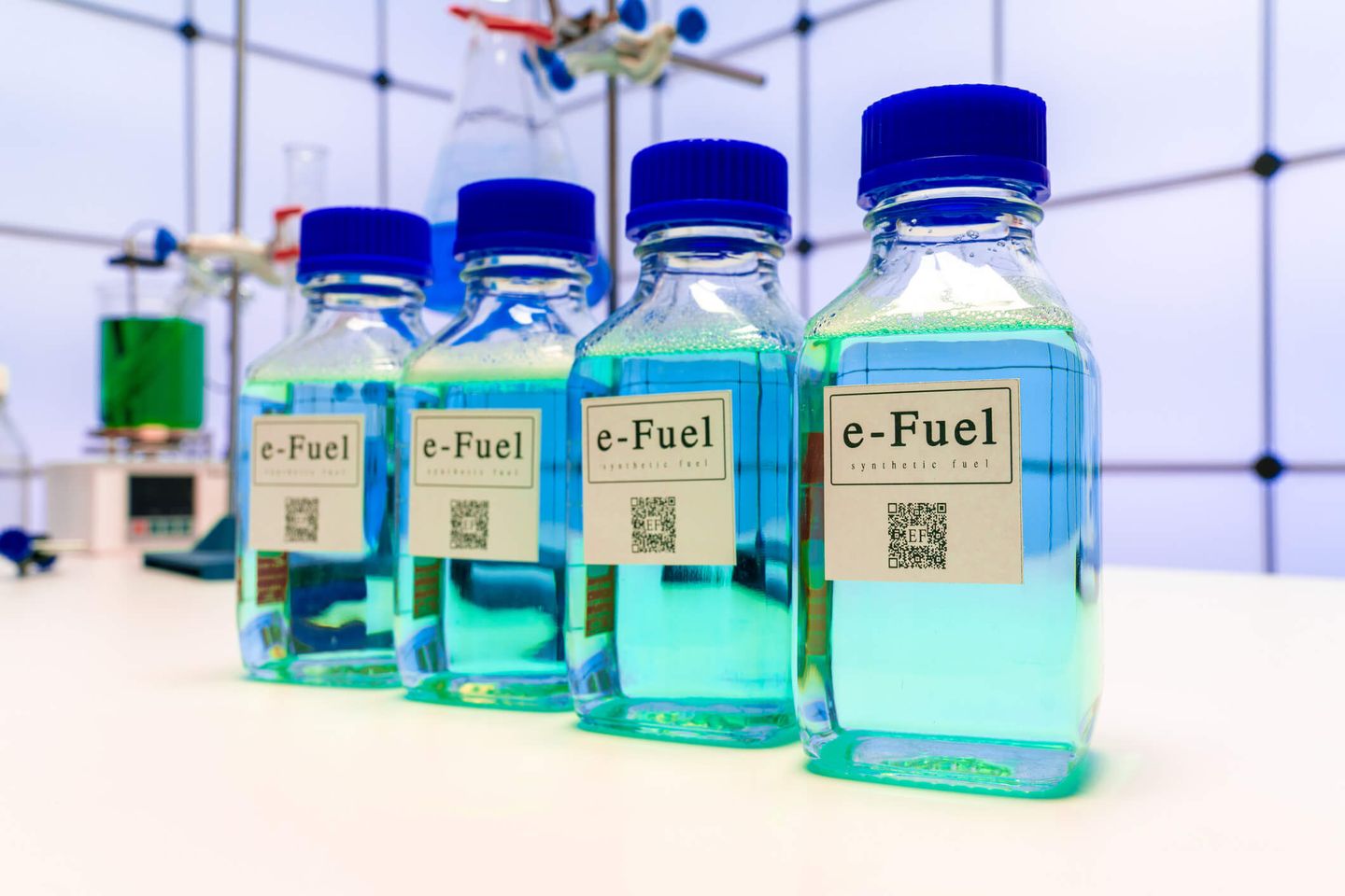 Flüssige E-Fuels in vier kleinen Flaschen stehen auf einer Arbeitsfläche in einem Labor. © WLADIMIR BULGAR/SCIENCE PHOTO LIBRARY / Science Photo Library via Getty Images