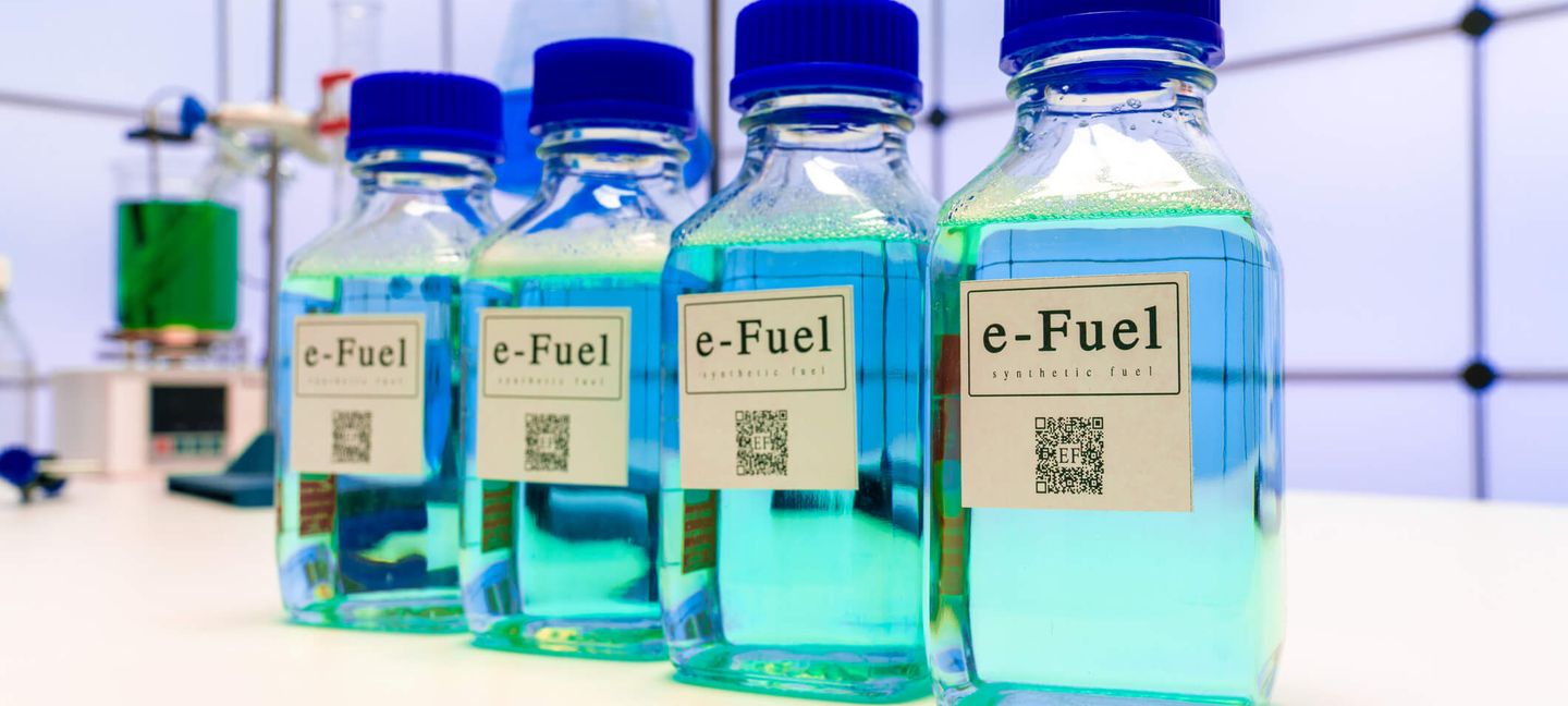 Flüssige E-Fuels in vier kleinen Flaschen stehen auf einer Arbeitsfläche in einem Labor. © WLADIMIR BULGAR/SCIENCE PHOTO LIBRARY / Science Photo Library via Getty Images