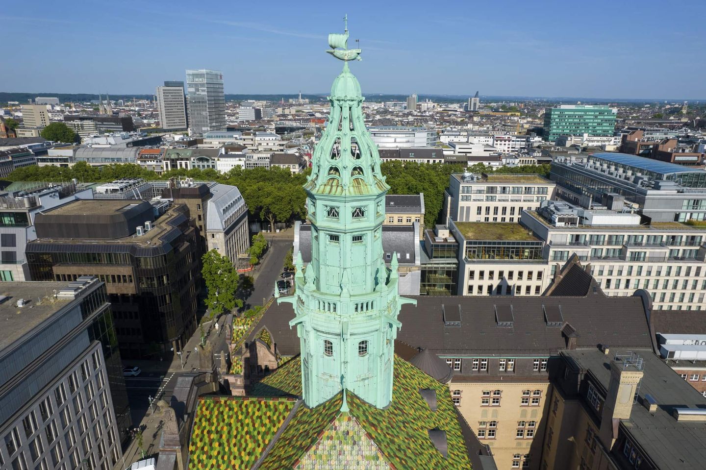 Historisches Gebäude in Düsseldorf mit grünem Kupferdach und Stadtsilhouette im Hintergrund. Getty
