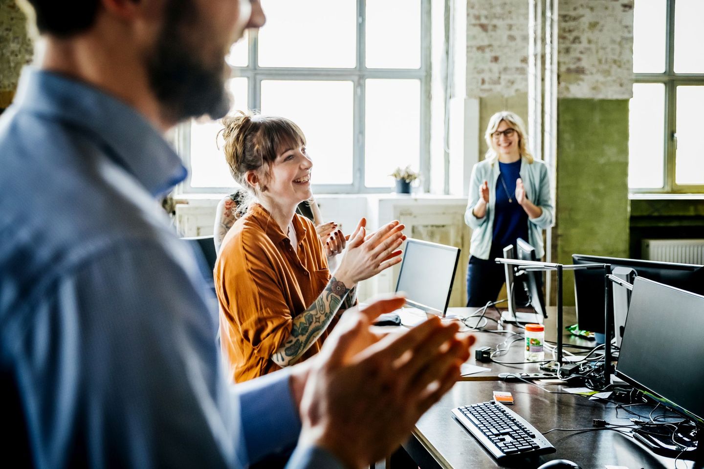 Ein Team jubelt im Büro über gemeinsame Erfolge. © Hinterhaus Productions / Stone via Getty Images