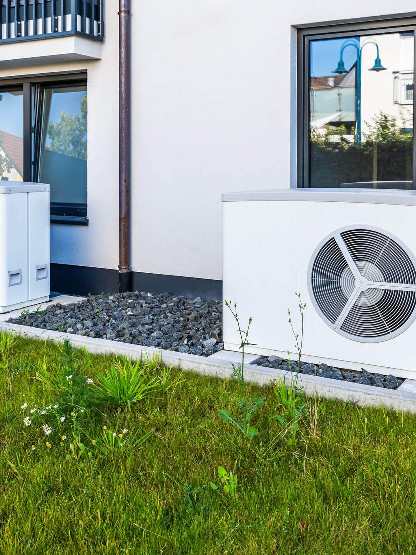 Zwei Wärmepumpen-Außengeräte vor einem modernen Wohnhaus. © rebca / iStock / Getty Images Plus via Getty Images © rebca / iStock / Getty Images Plus via Getty Images