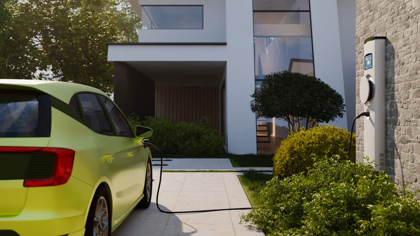 Ein E-Auto wird in einer privaten Einfahrt an einer solaren Ladestation aufgeladen. © piranka / E+ via Getty Images