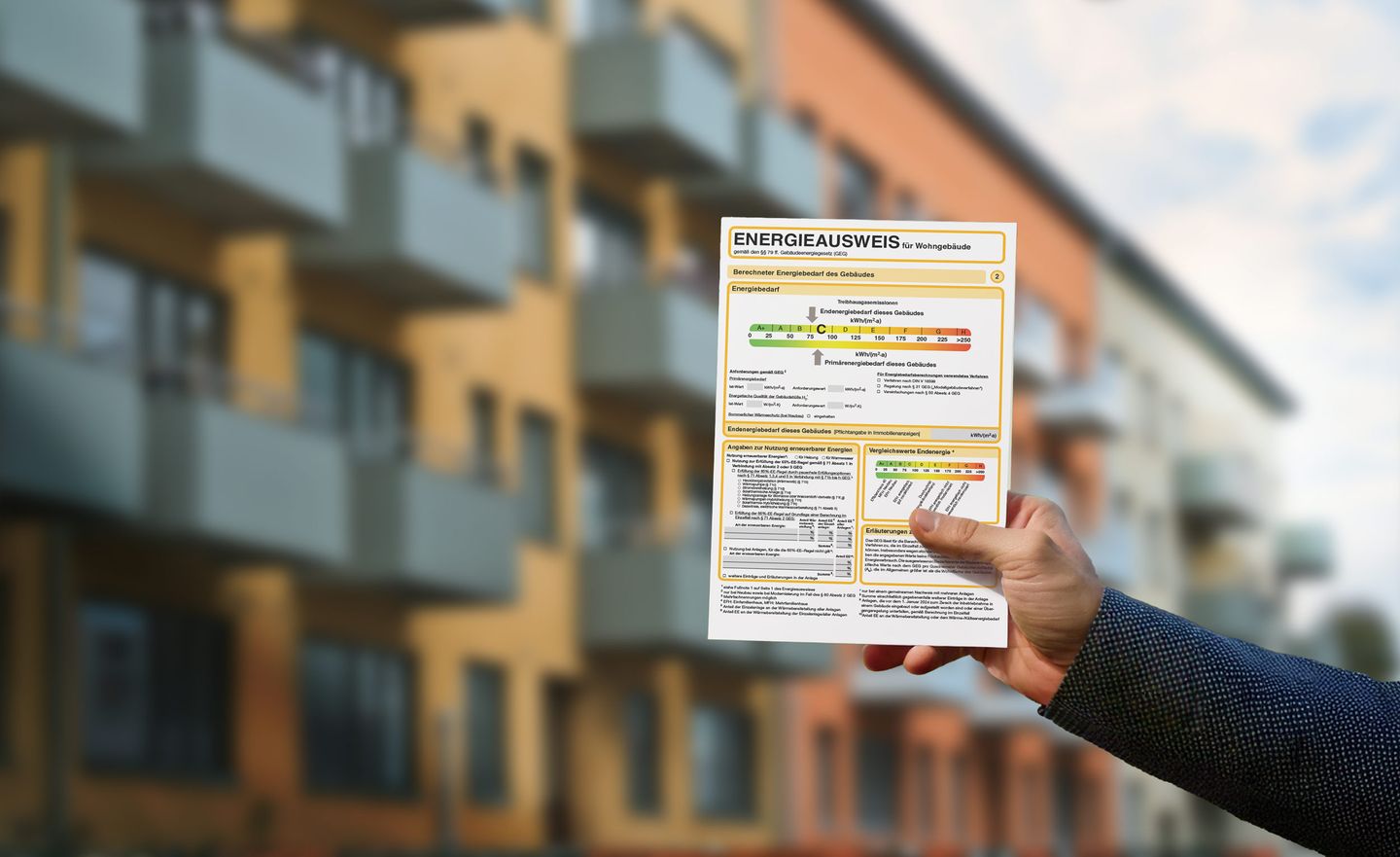 Ein Energieausweis vor einem Mehrfamilienhaus
