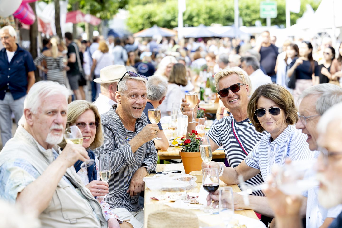 Gäste sitzen an einer Biertischgarnitur und verkosten Wein und Champagner.  © Destination Düsseldorf Veranstaltungs GmbH / Wellfairs GmbH via www.duesseldorfer-frankreich-fest.de