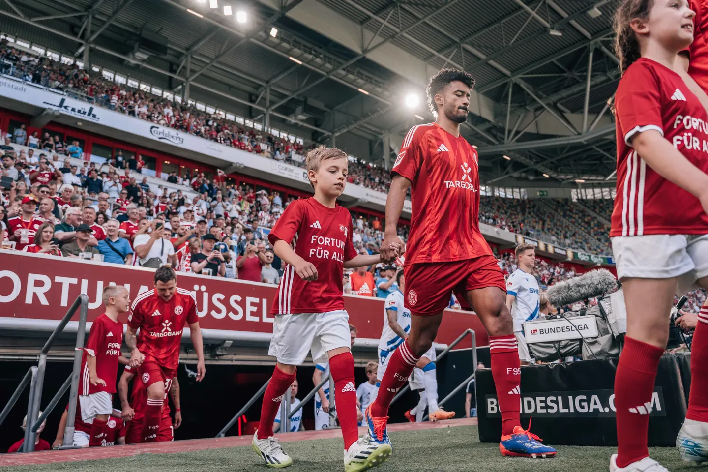 Fortuna-Spieler mit Einlaufkindern im Stadion in Düsseldorf
