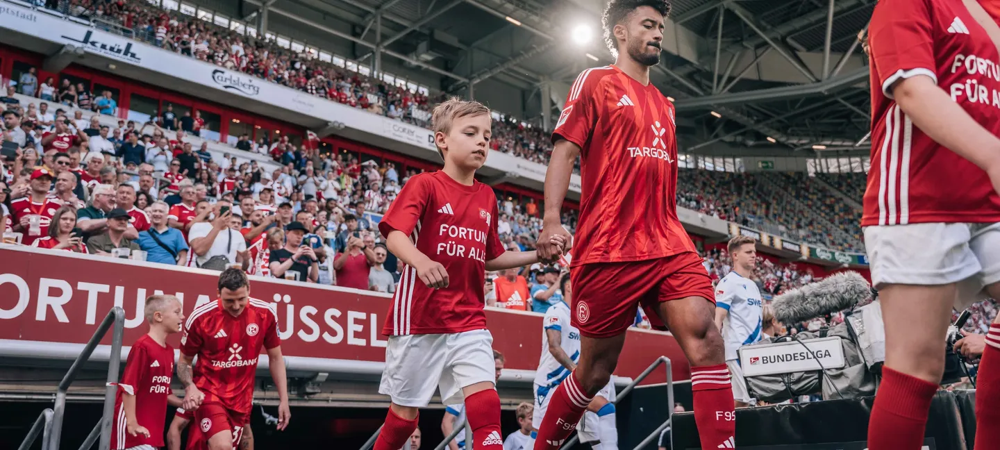 Fortuna-Spieler mit Einlaufkindern im Stadion in Düsseldorf
