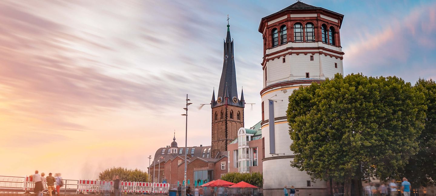 Der Schlossturm auf dem Burgplatz in Düsseldorf mit der Lambertus-Kirche im Hintergrund. © frantic00 / iStock / Getty Images Plus via Getty Images