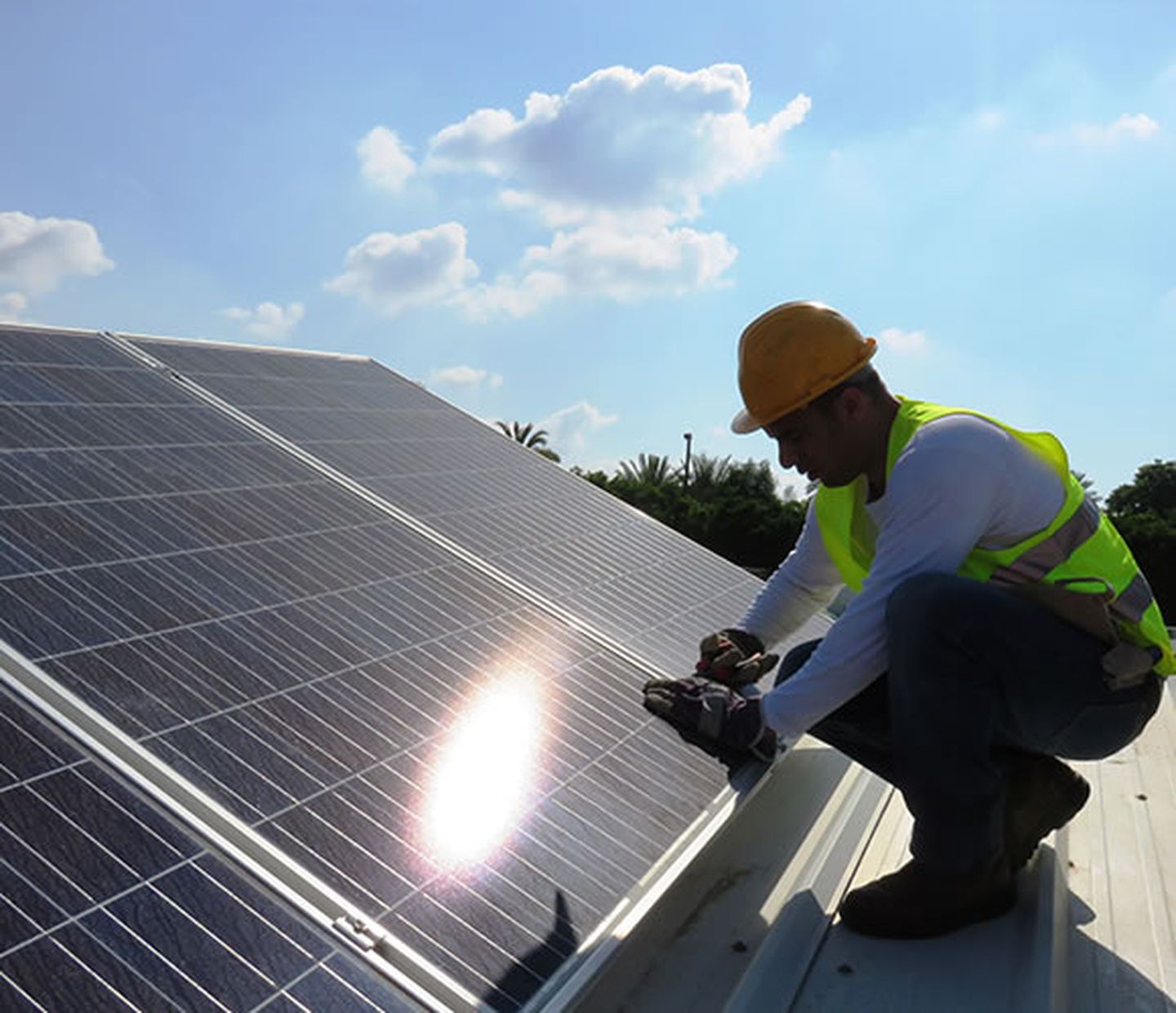 Ein Monteur überprüft ein Solarmodul auf einem Dach