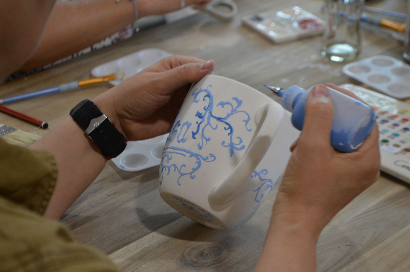 Eine Frau bemalt eine Tasse