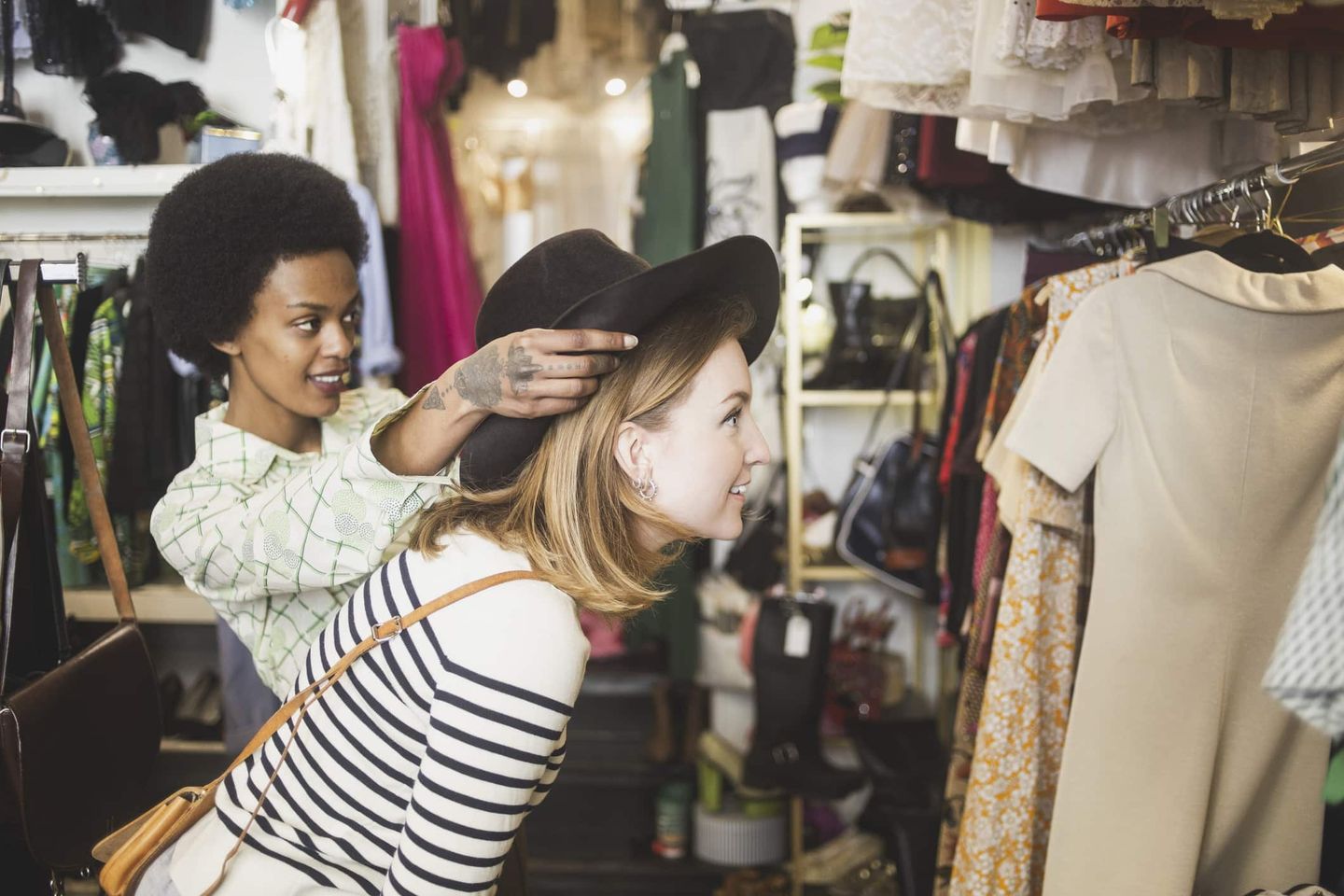 Zwei Frauen probieren Kleidung in einem Second-Hand-Laden an. Getty