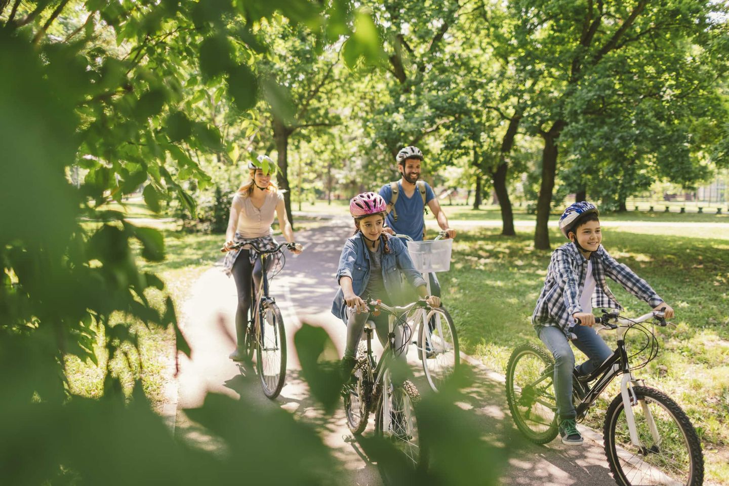 Familie mit Kindern fährt gemeinsam Fahrrad im Park Getty