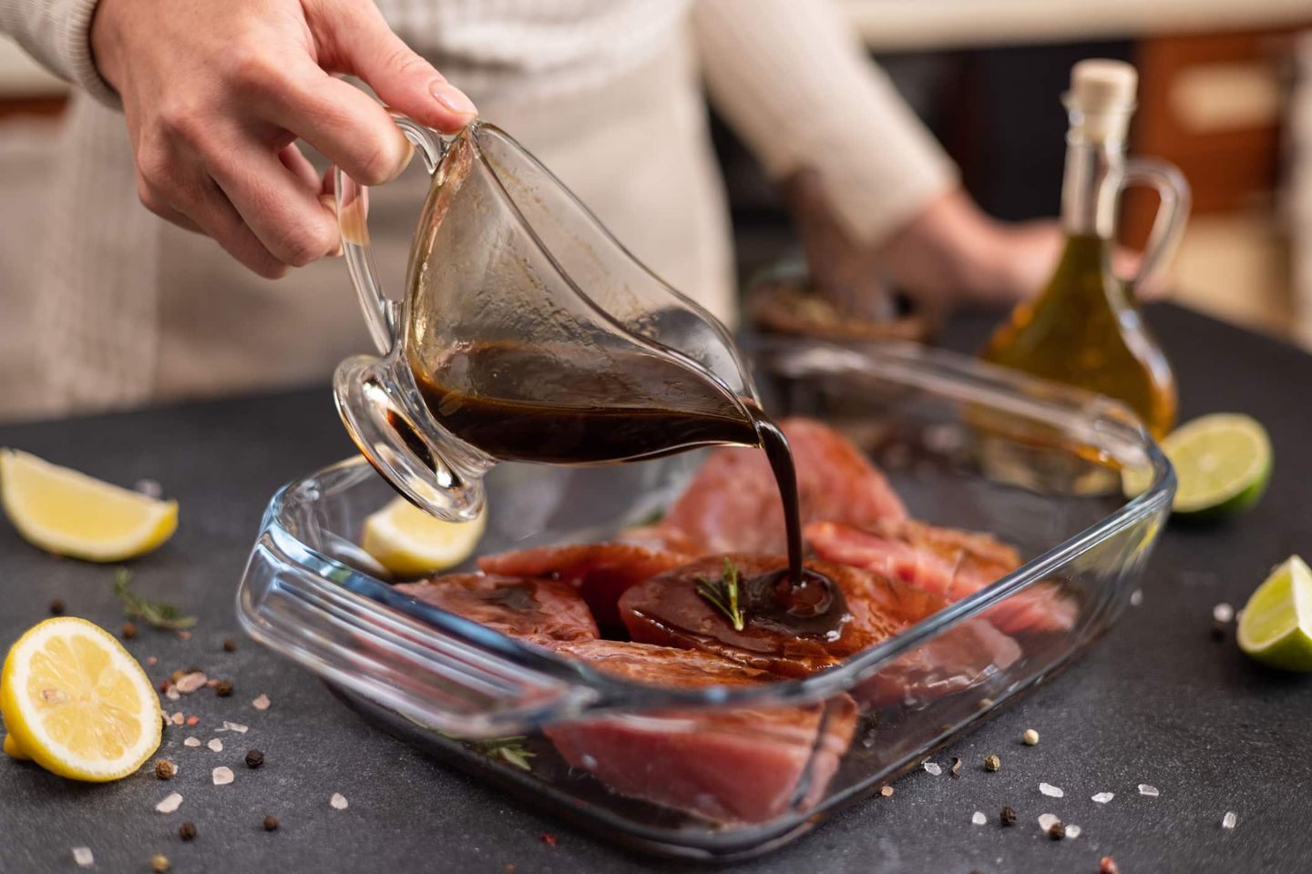 Marinade wird über frischen Fisch in einer Glasschale gegossen. Getty