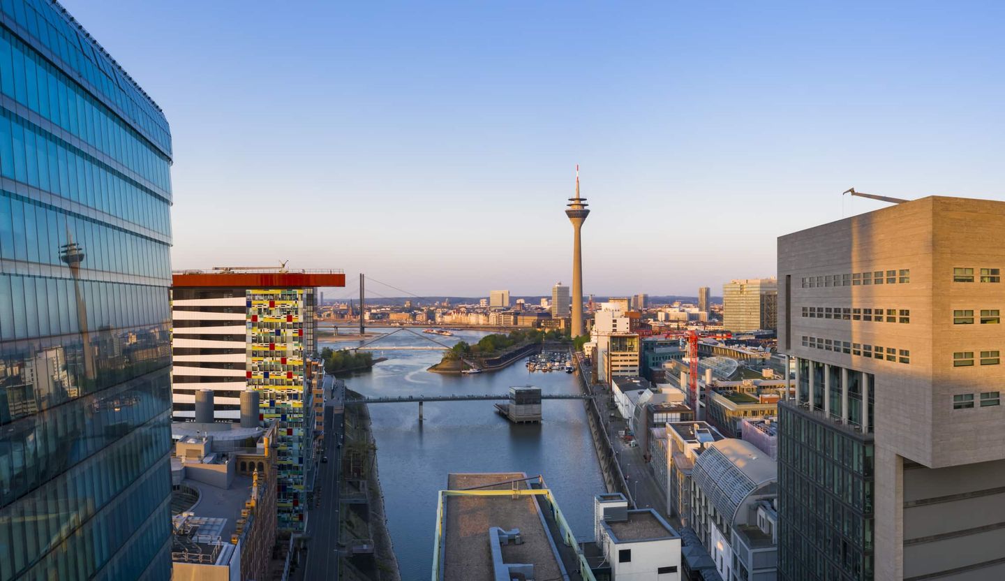 Skyline von Düsseldorf mit Medienhafen, Rheinturm und Brücken bei Sonnenuntergang. Getty