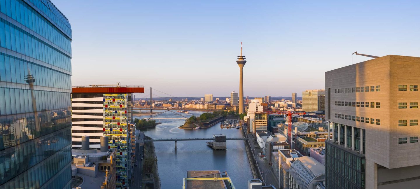 Skyline von Düsseldorf mit Medienhafen, Rheinturm und Brücken bei Sonnenuntergang. Getty