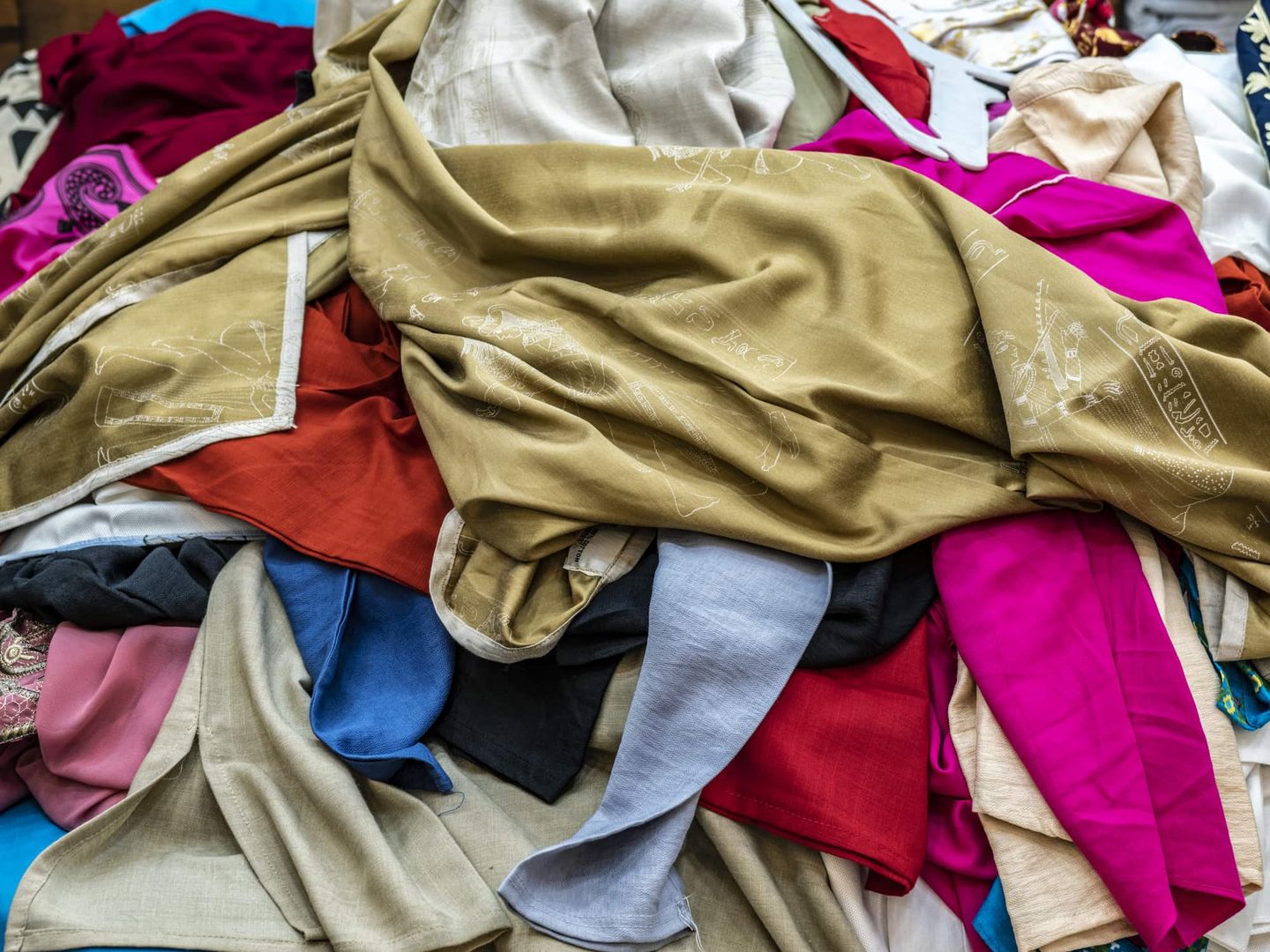 Ein Stapel bunter Kleidung liegt unsortiert auf einem Haufen. Getty