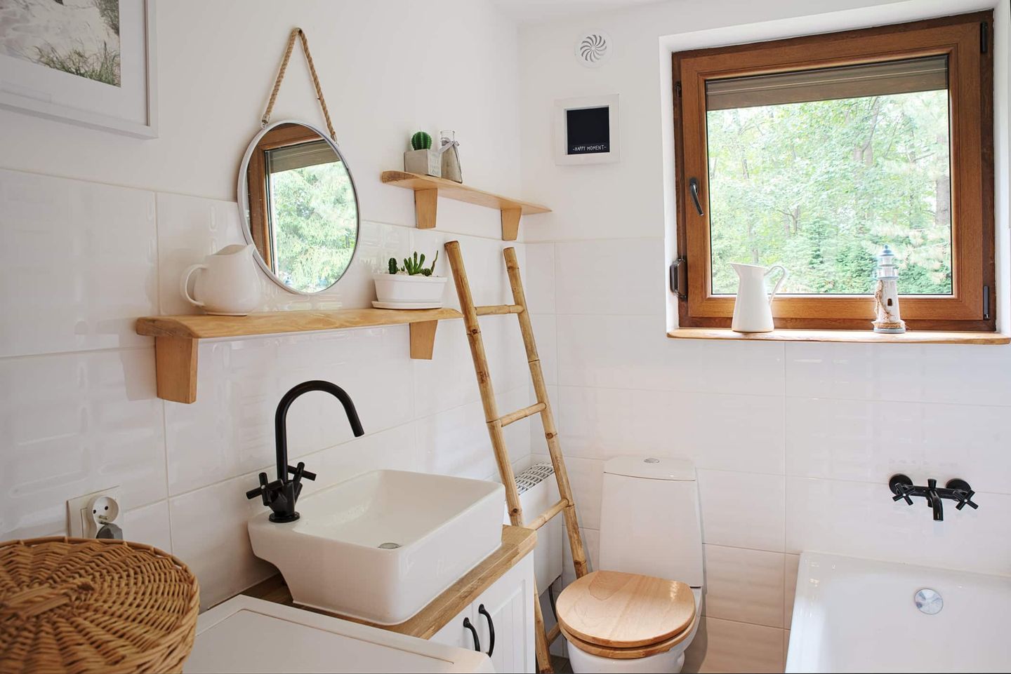 Modernes kleines Badezimmer im skandinavischen Stil mit Holz- und Weiß-Elementen, rundem Spiegel und Leiter als Dekoration. Getty