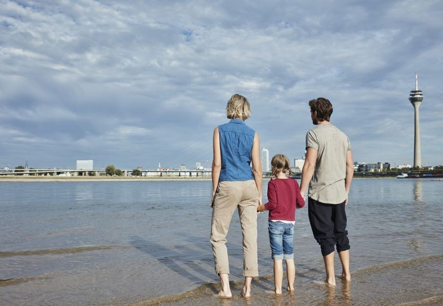 Eine glückliche Familie bei einer Aktivität in Düsseldorf am Rheinufer. © Westend61 via Getty Images