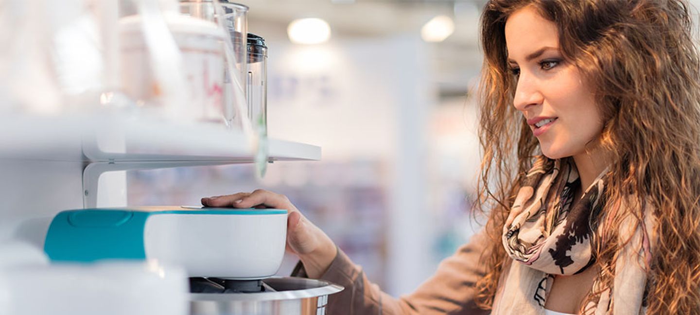 Frau begutachtet Küchenmaschine anhand des Energielabels