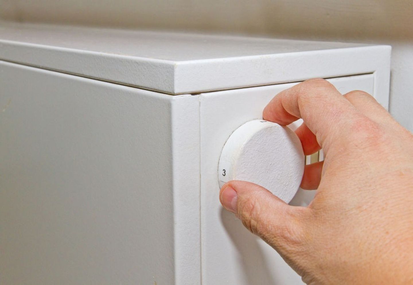 Nahaufnahme einer Hand, die eine Nachtspeicherheizung einstellt. © fotojog / iStock via Getty Images