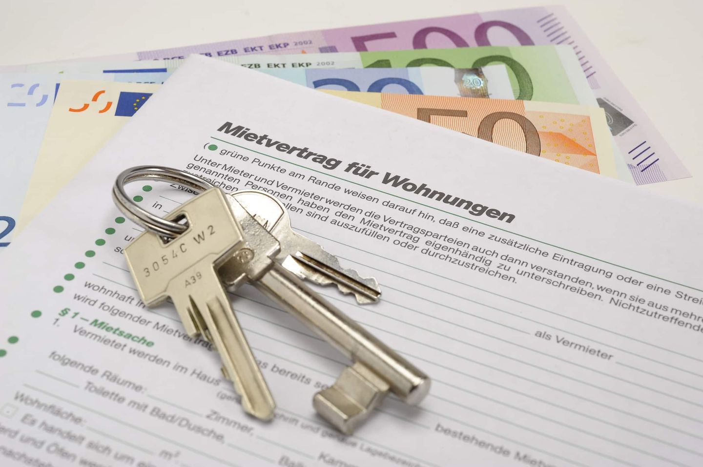 Mietvertrag mit Schlüsselbund und Euro-Scheinen. Getty