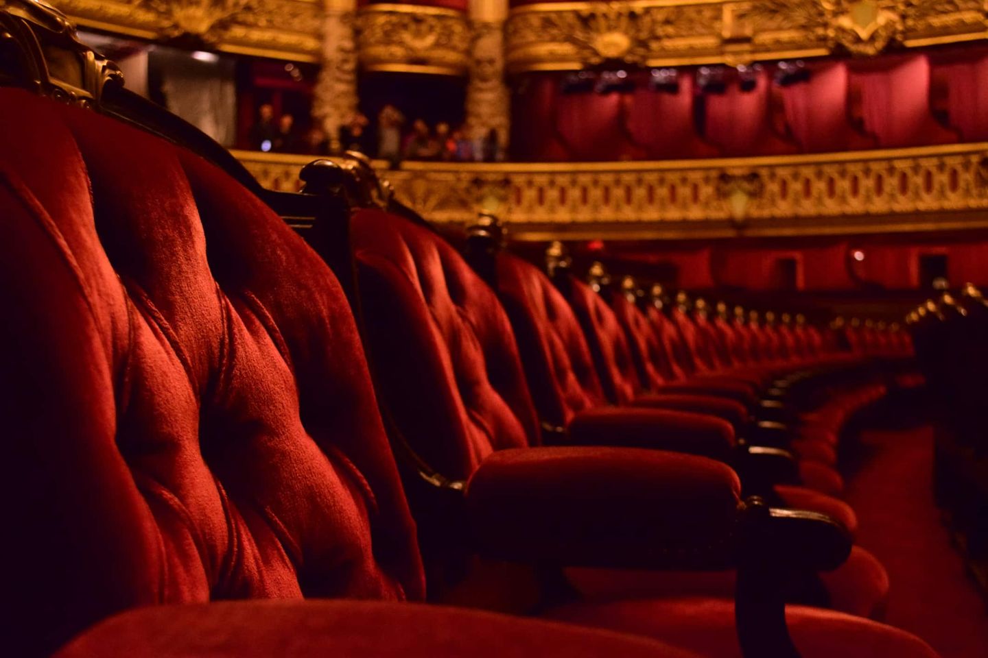 Rote Samtsessel in einer prunkvollen Oper mit goldener Verzierung. Getty