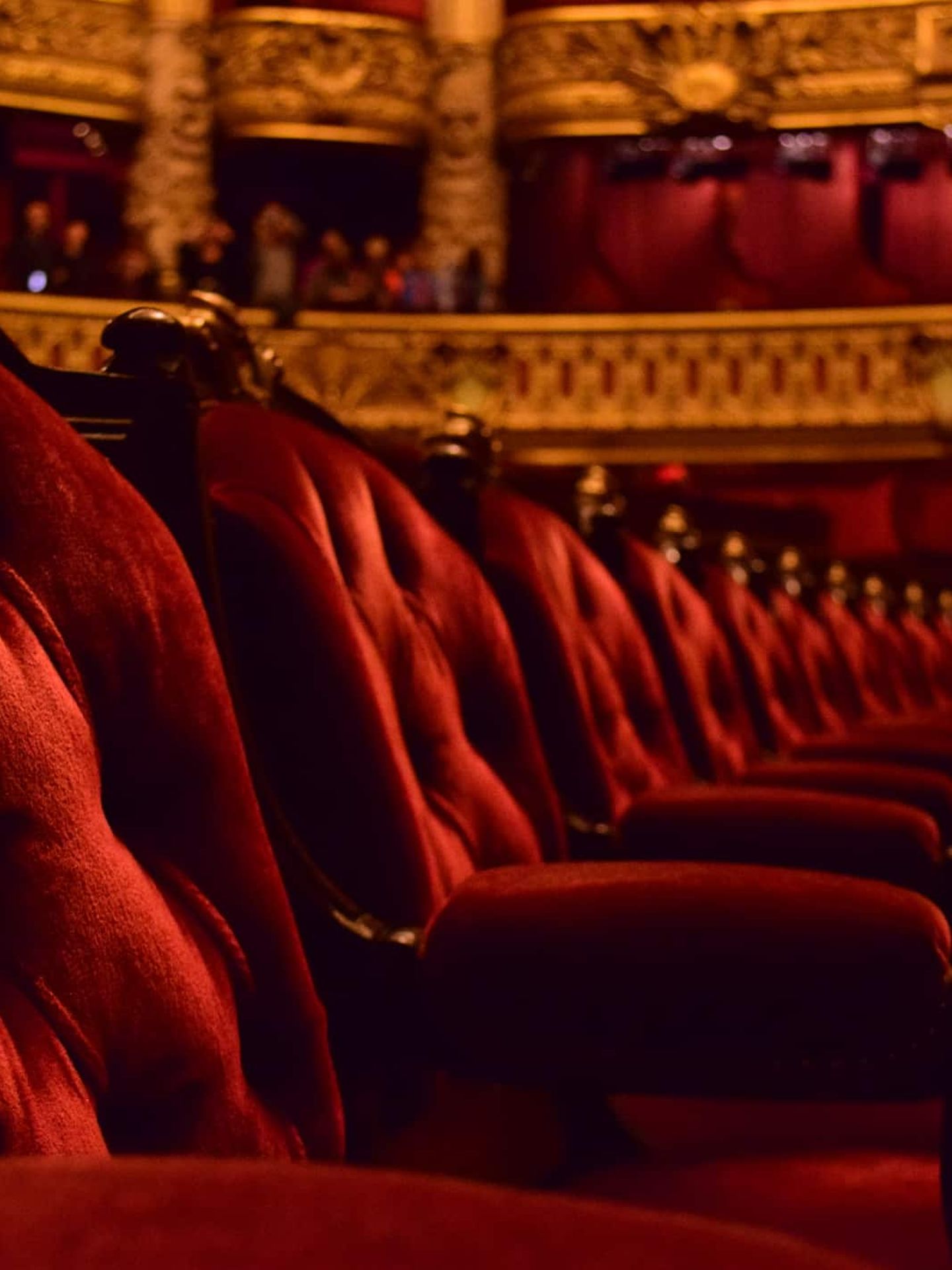 Rote Samtsessel in einer prunkvollen Oper mit goldener Verzierung. Getty