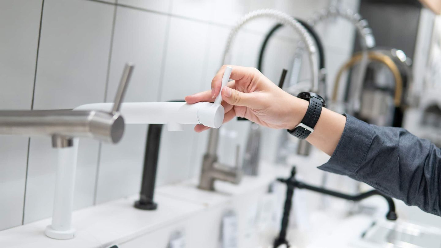 Eine Frau, die sich im Baumarkt smarte Wasserhähne anschaut.