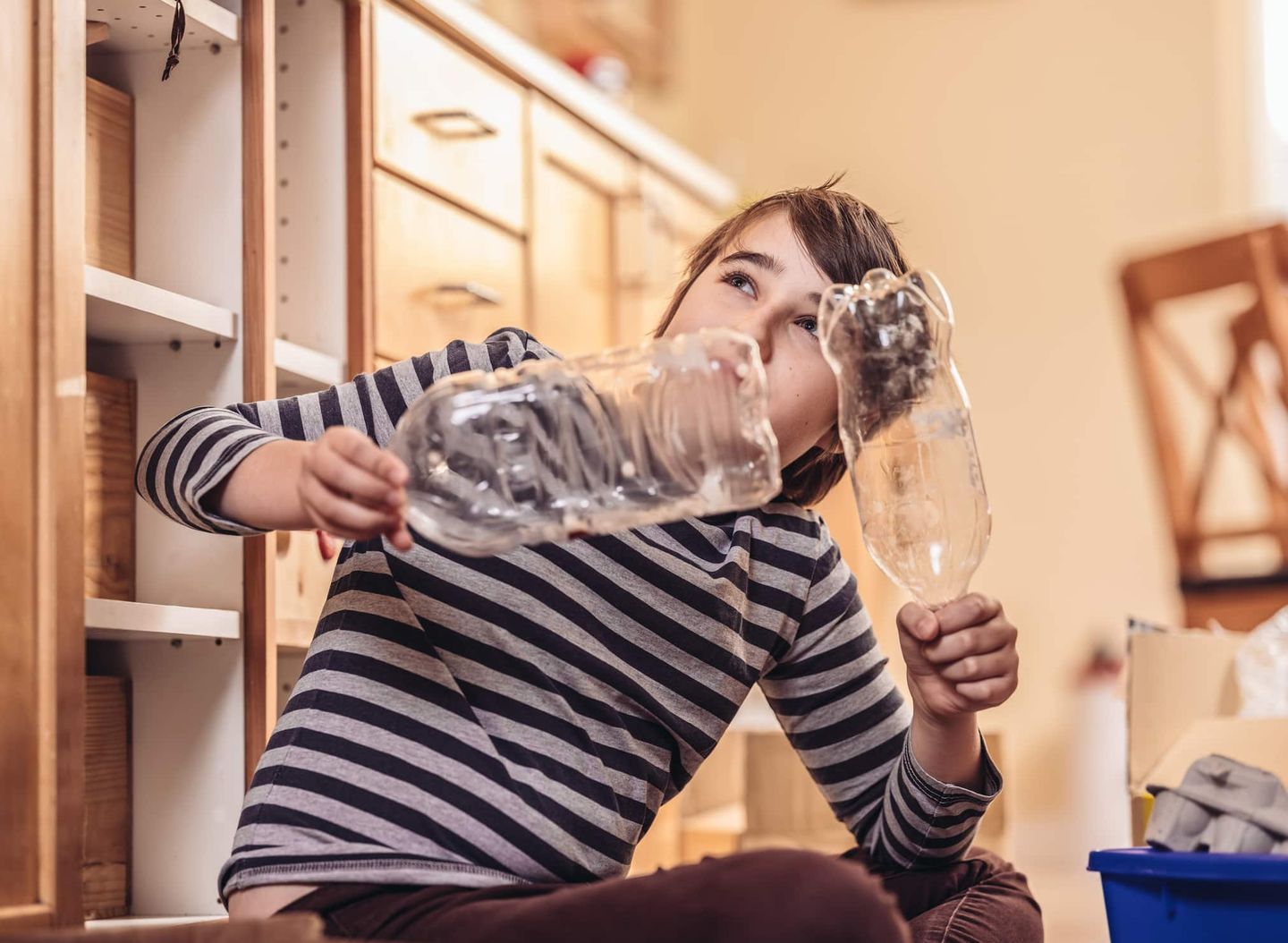 Kind bastelt mit Plastikflaschen als Recycling-Experiment. Getty