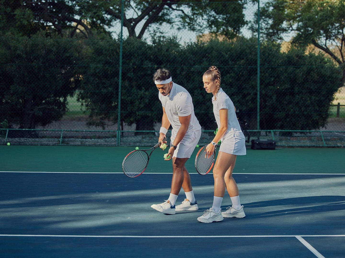 Nahaufnahme der Füße eines Spielers und eines Tennisschlägers. Durch Bewegung wird Schotter in die Luft gewirbelt.