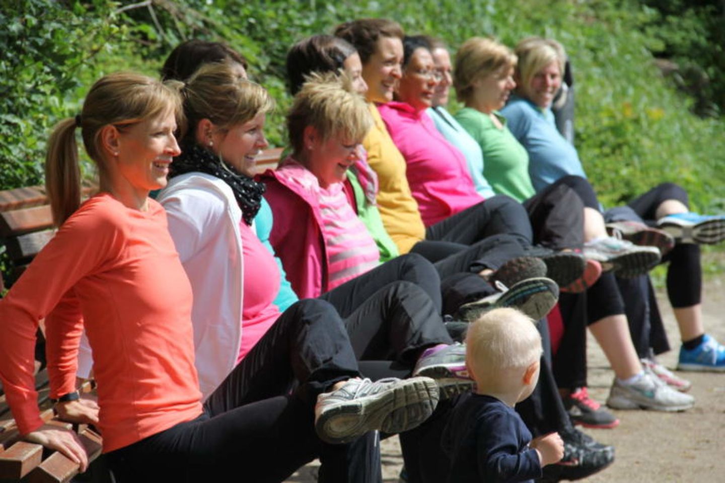 Frauen machen Dips an einer Parkbank