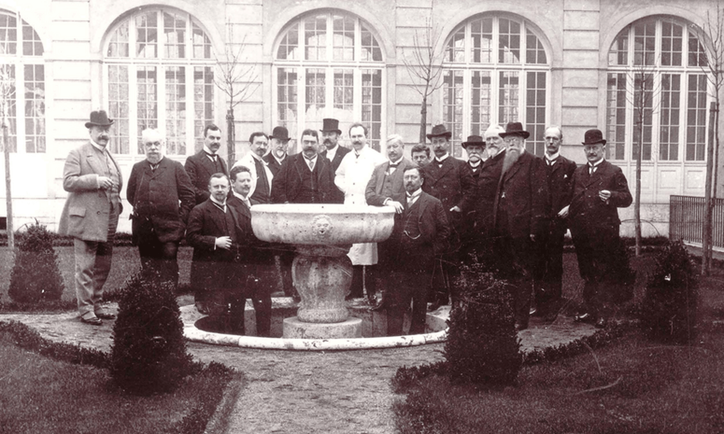 Gründungsmitglieder des Deutschen Paritätischen Wohlfahrtsverbands stehen um einen Brunnen herum.