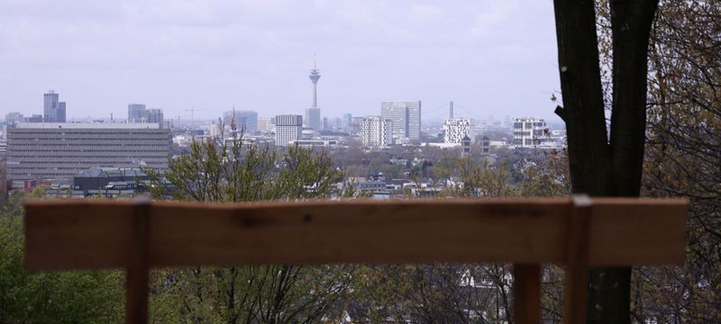 Eine Bank im Grafenberger Wald mit guter Aussicht auf die Stadt und den Rheinturm in der Ferne. © Young via Landeshauptstadt Düsseldorf © Young via Landeshauptstadt Düsseldorf