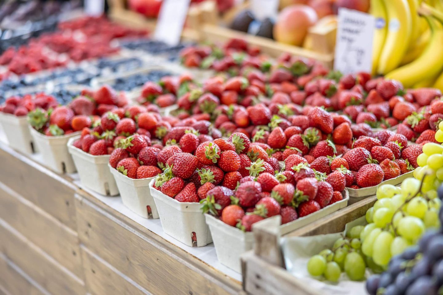 Frische Erdbeeren in Schalen auf einem Wochenmarktstand Getty