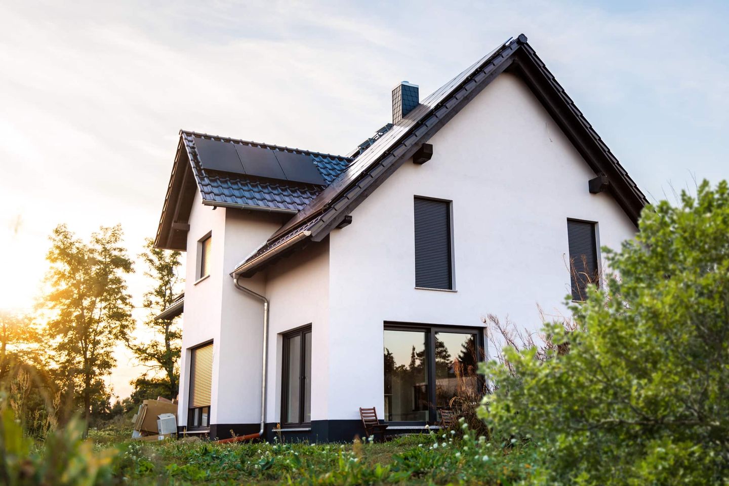Modernes Einfamilienhaus mit Solaranlage auf dem Dach bei Sonnenuntergang. Getty